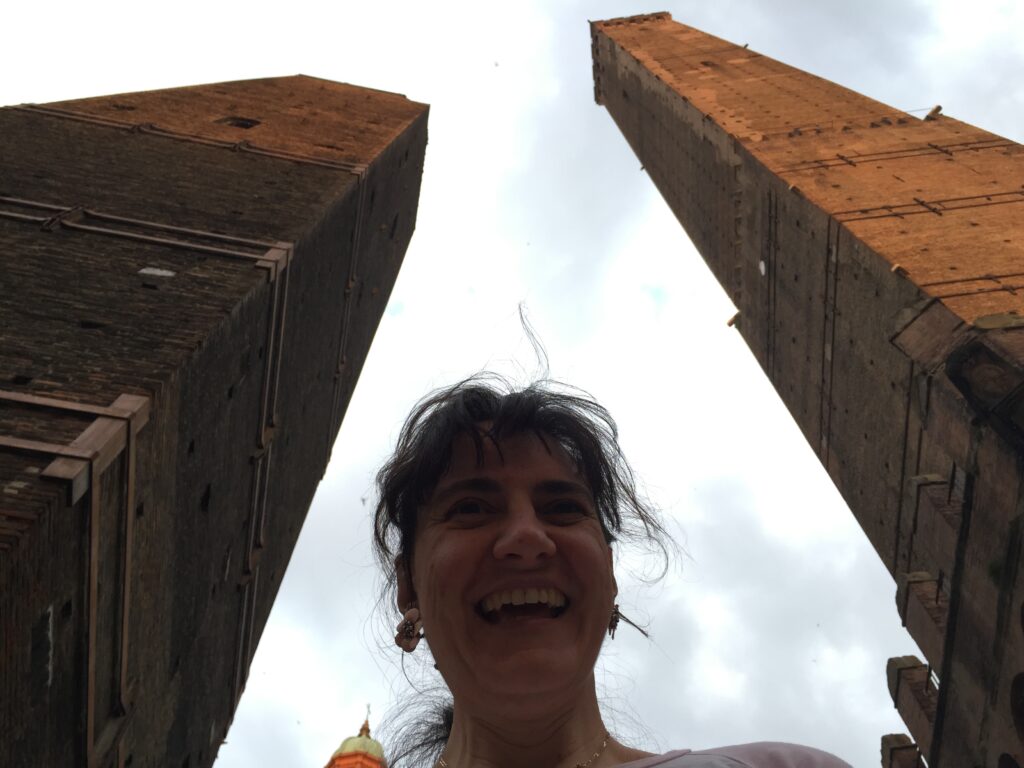 Katia Caravello in primo piano e sullo sfondo le torri di Bologna